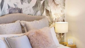 A neatly made bed with a fluffy pink throw, white pillows, and rolled towels. - 12 Calming Coral Beach Beautiful 2BRM (Scarborough)