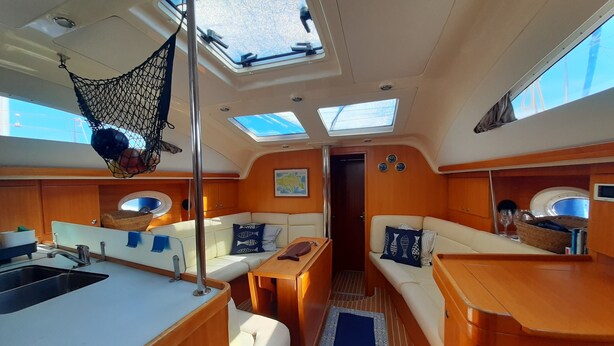 A boat interior with a kitchen area, seating, and a netted storage. - Sailing between the Sporades Islands (Sciato)