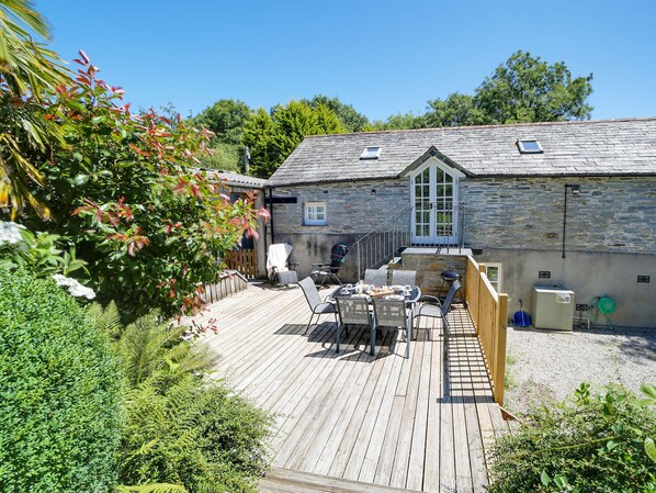 A stone building with a wooden deck, outdoor seating, and a barbecue area. - Stunning barn in an idyllic hamlet, sleeps 6 + dogs (Lanteglos)