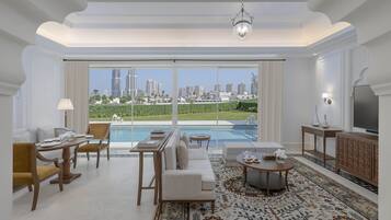 A spacious living room with a large window overlooking a cityscape, a pool, and a modern interior design.