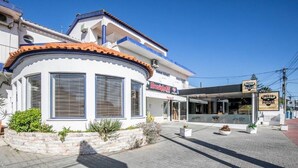Un edificio con fachada blanca, esquina curva y tejado de tejas.