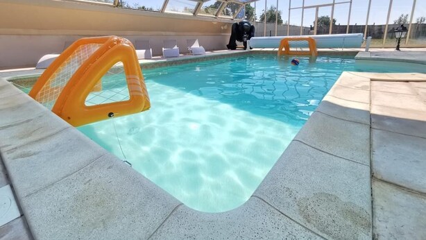 An indoor swimming pool with clear water, a glass ceiling, and a lifeguard chair. - L'Antidote, estate with heated indoor pool 1h30 from Paris (Coulours)