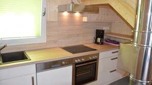 Una cocina moderna con horno integrado, lavavajillas y cafetera.
