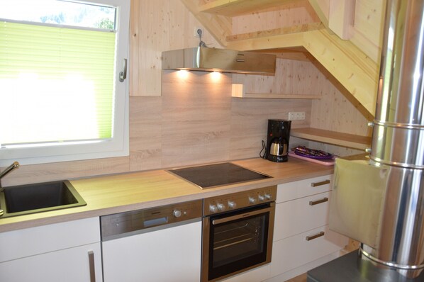 A modern kitchen with a built-in oven, a dishwasher, and a coffee maker.