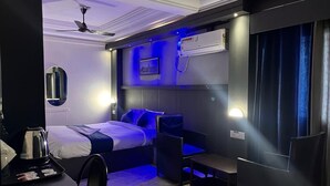 A modern hotel room with a bed, a desk, a chair, and a ceiling fan. - Sivabhagya SKR Madurai (Madurai)