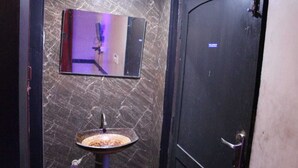 A bathroom with a marble wall, a sink, and a door. - Sivabhagya SKR Madurai (Madurai)