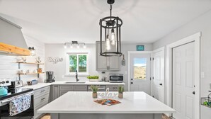 Una cocina moderna con una isla central, electrodomésticos integrados y vistas al exterior.