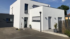 A modern two-story building with a flat roof, large windows, and a small front porch. - Apartment in detached house (Colmar)