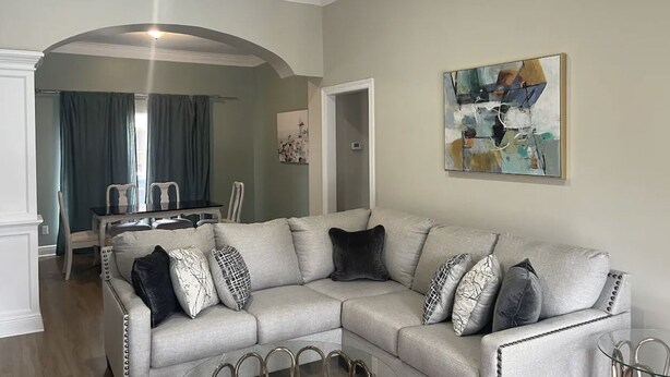 A living room with a sectional sofa, a glass coffee table, and a dining area with a table and chairs. - Near Hospital & Shopping Centers- 3/2 with pool (Lafayette)
