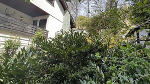 A white building with a balcony and a stone wall. - Villa close to Winterberg and Willingen (Bruchhausen)