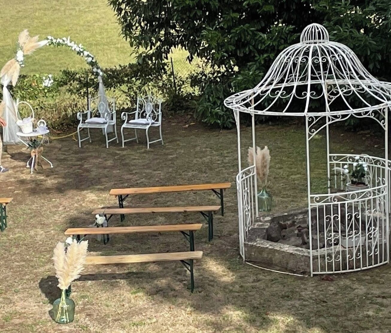 Outdoor seating with benches and a white metal gazebo.