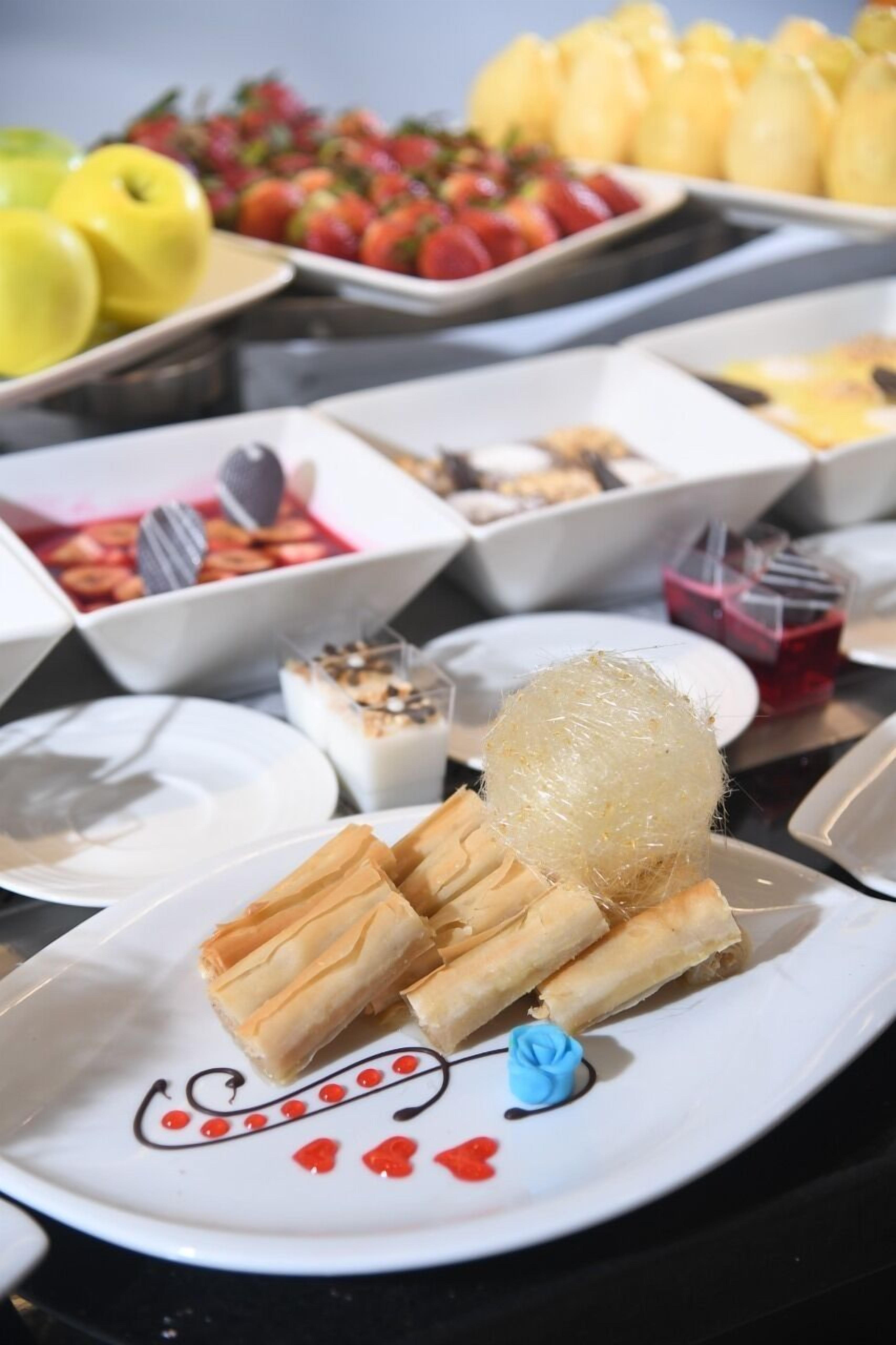 Ein reichhaltiges Buffet mit verschiedenen Speisen, darunter Gebäck, Früchte und Desserts.