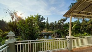A wooden deck with a white railing, overlooking a pond and lush greenery. - Resort house - 2 min walk to the beach (Amphoe Bang Saphan)