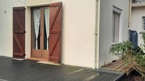 A building with two wooden doors, a small porch, and a water tank outside.