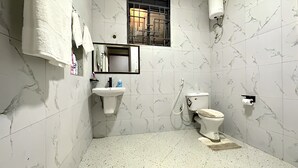 A bathroom with a toilet, sink, and mirror.