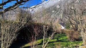 A house with a visible garden and a mountain in the background. - WONDERFUL SPACIOUS CHALET IN BOURG D’OISANS - SLEEPS 10(*supplement available up to 16) (Le Bourg-d'Oisans)
