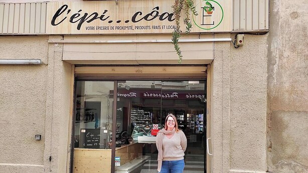 Une devanture de magasin avec une enseigne indiquant « l’épi…coa » et un logo représentant une plante.