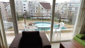 Un balcon donnant sur une piscine et des immeubles d’habitation.