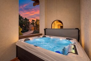 A hot tub with a view of a sunset and trees.