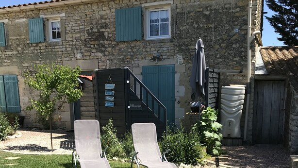 A stone building with two lounge chairs in the yard. - A peaceful, restful little corner (Annezay)