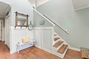 A staircase with wooden steps and white walls. - Sunny Side Up - Beautiful OKI beach home on cul-de-sac.  Short walk to beach. (Oak Island)