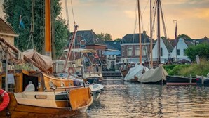 Ein Kanal mit vertäuten Booten, umgeben von traditionellen Häusern.