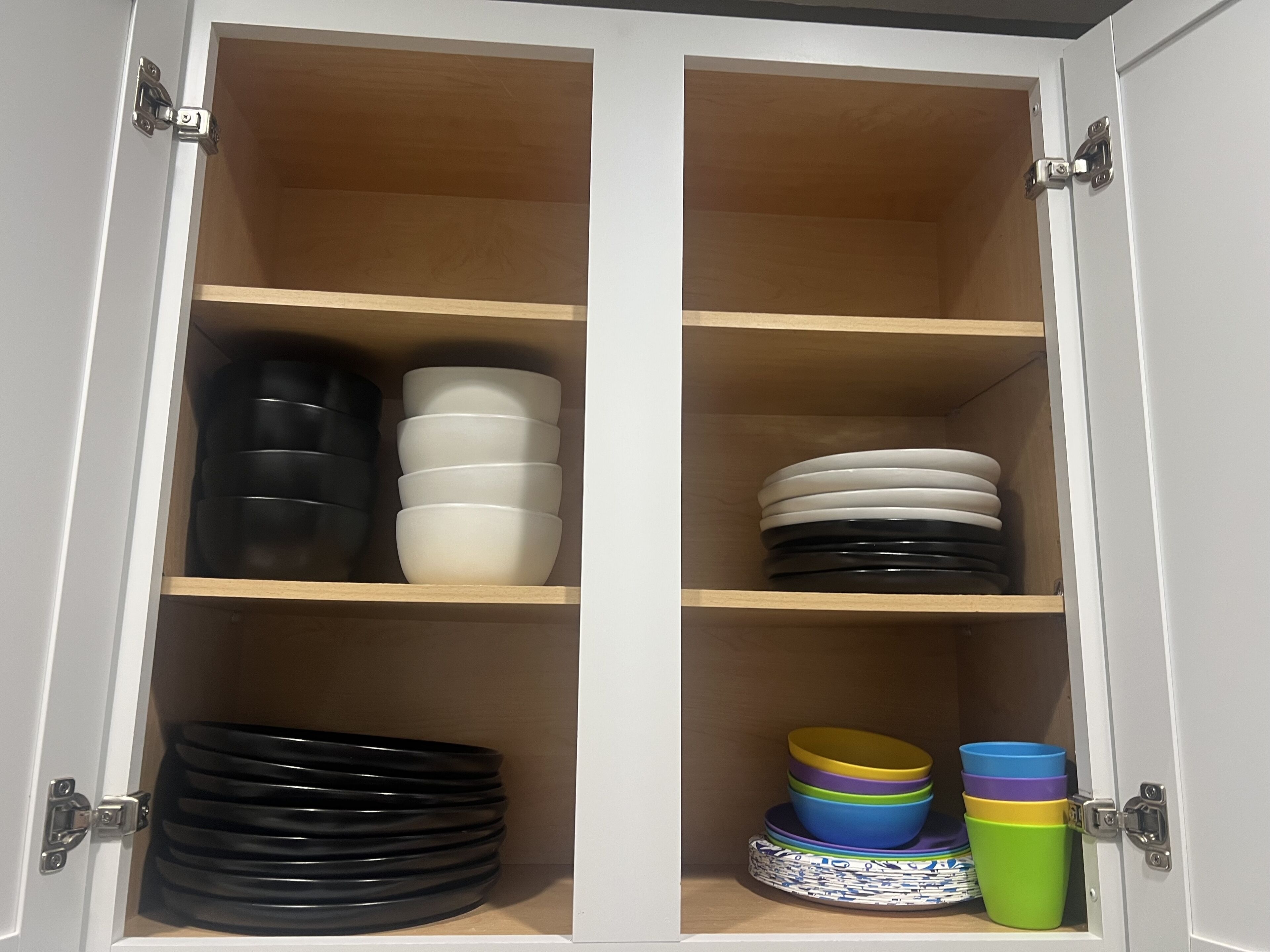 A cabinet with multiple shelves containing various bowls and plates.