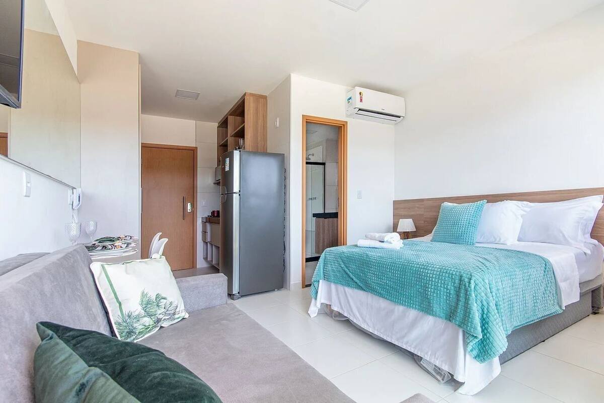 Une chambre d’hôtel équipée d’un lit, d’un canapé, d’un réfrigérateur et d’une armoire.