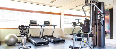 A gym with treadmills, an elliptical, and a weight machine.