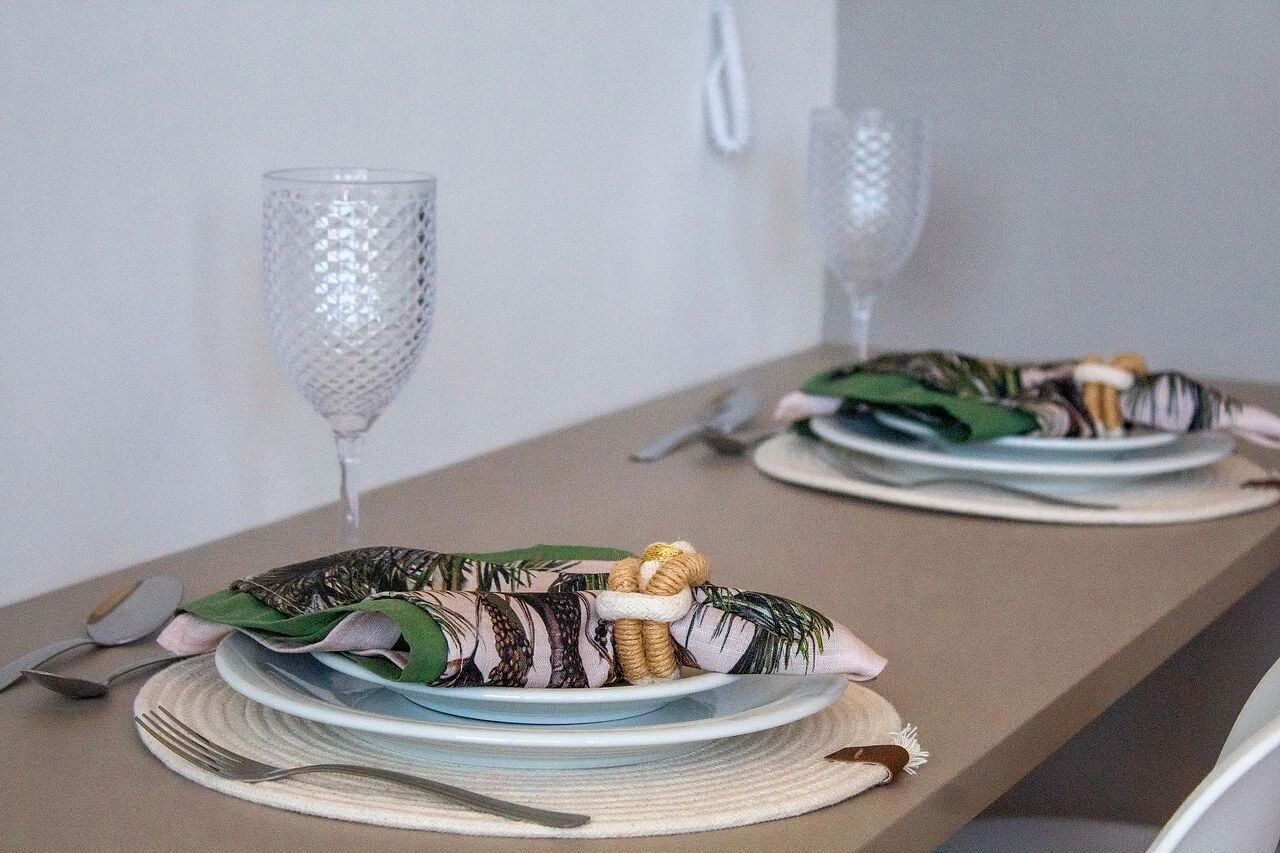 A dining table set with plates, cutlery, and a decorative centerpiece.