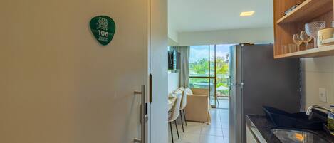 A modern kitchen with a dining area, a balcony with a view, and a number sign on the wall.