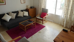 A living room with a sofa, a rocking chair, a coffee table, and a wooden cabinet.
