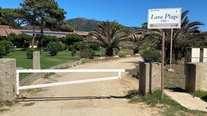 A sign for 'Lava Plage' with a gate and surrounding greenery. - Lava Plage - Feet in the water (appietto)