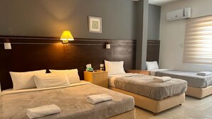A hotel room with two beds, a nightstand, a lamp, and a window with blinds. - Petra town check-Inn (Wadi Musa)