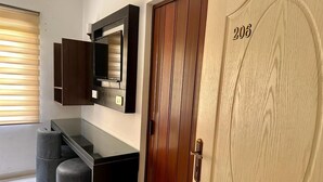 A room with a wooden door marked with the number 206, a black countertop, and a mirror above it. - Petra town check-Inn (Wadi Musa)