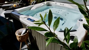 Un jacuzzi con panel de control, rodeado de follaje.
