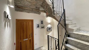 A staircase with a stone wall, a wooden door, and a metal railing. - Large, Authentic 2-bed Apartment, Panoramic Views (Bosa)