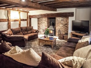 Una sala de estar acogedora con sofás de cuero, una chimenea y un televisor.
