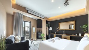 A modern hotel room with a large bed, a sofa, a desk, and a balcony. - Clyde Athens by Nin&Bau (Athens)