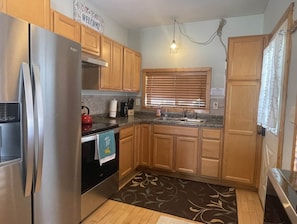 Kitchen area with a refrigerator, sink, and kettle, offering a convenient space for meal preparation.