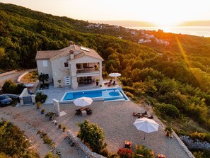 A two-story house with a swimming pool, surrounded by a gravel driveway and lush greenery. - Penthouse with excellent sea views (Brsec)
