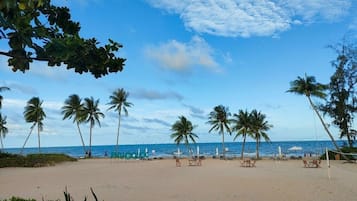 On the beach, white sand, sun-loungers, beach umbrellas