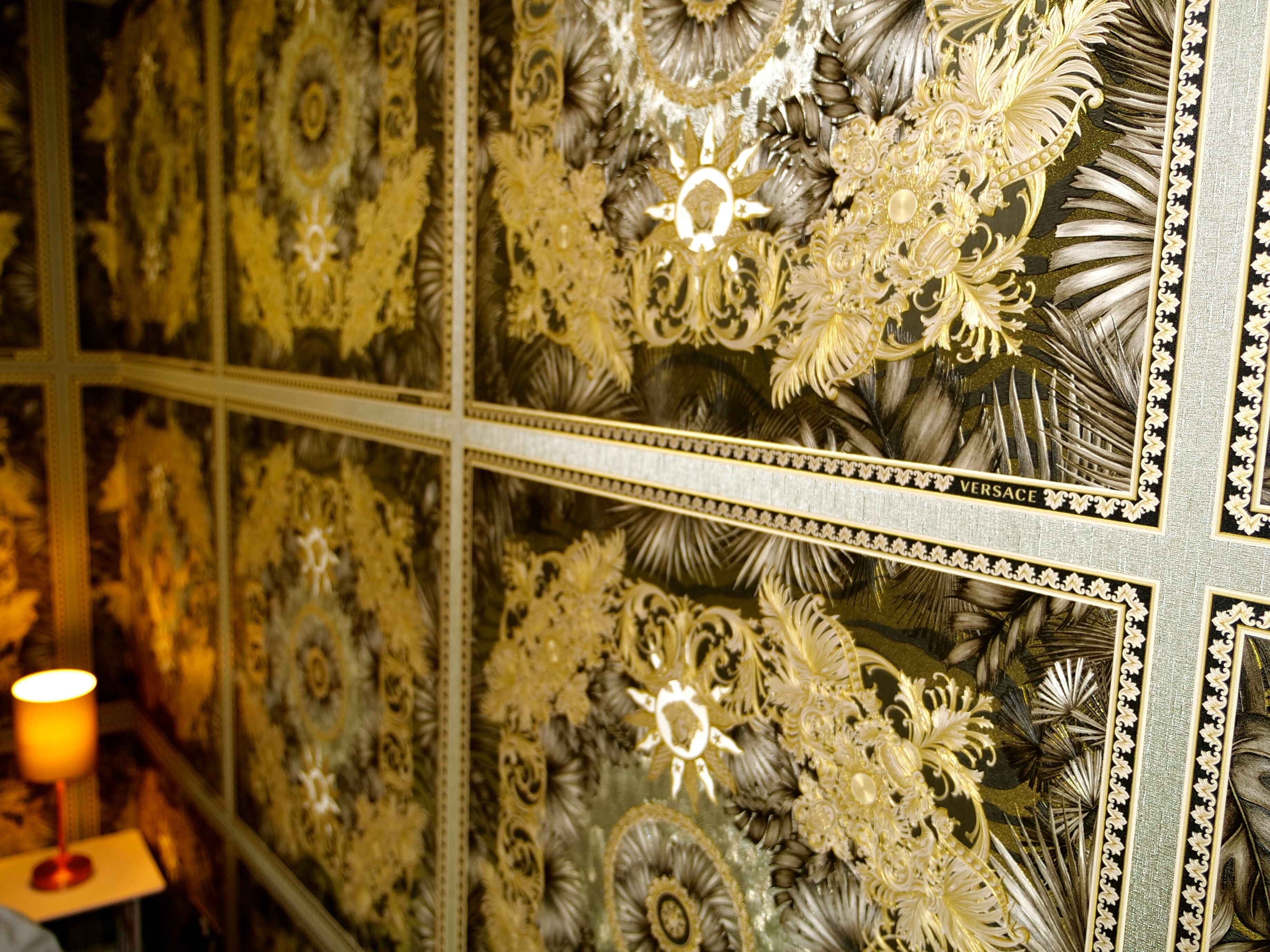 Un mur orné de motifs floraux et un miroir encadré.