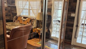 Une pièce confortable avec un canapé, une lampe et une fenêtre avec des rideaux.