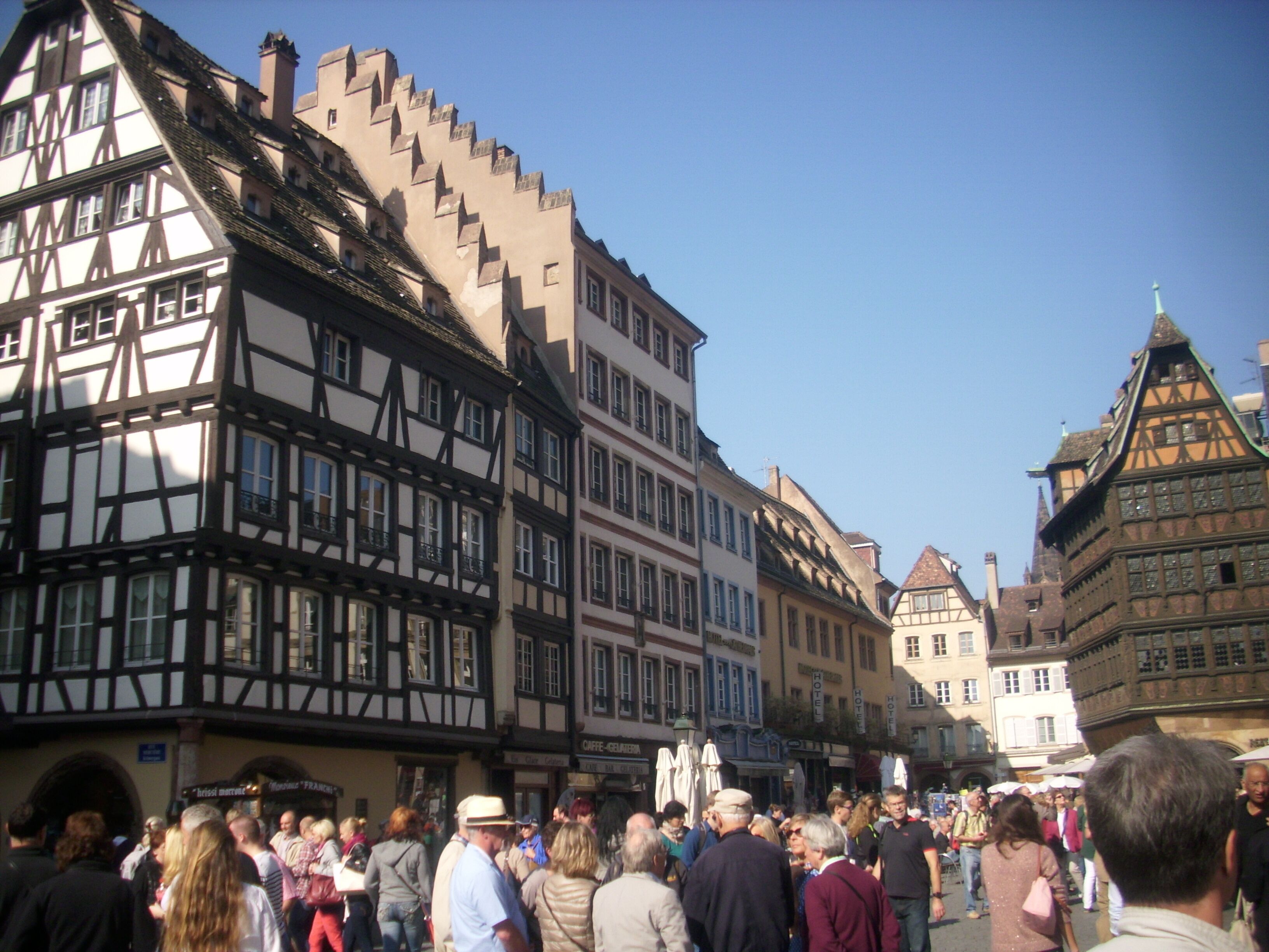 Een drukke straat met traditionele vakwerkhuizen, wat wijst op een historische Europese stad.