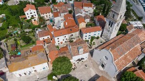 An aerial view of a historic town with traditional buildings, a prominent church tower, and a central square. - Impeccable 4-bed Apartment in Osor (Mali Losinj)