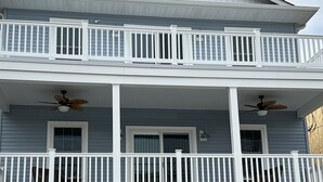 Une maison à deux étages avec un balcon, un porche à l’avant et un garage.