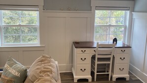A room with a desk, two windows, a couch, and a ceiling light. - 4-minute walk to beautiful Emerald Isle beach access. (Emerald Isle)