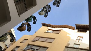 A multi-story building with a yellow facade, multiple windows, and balconies. - Oro Mono (Florence)