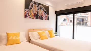 Ett hotellrum med två sängar, ett stort fönster och en tavla med ett zebrabild på väggen.